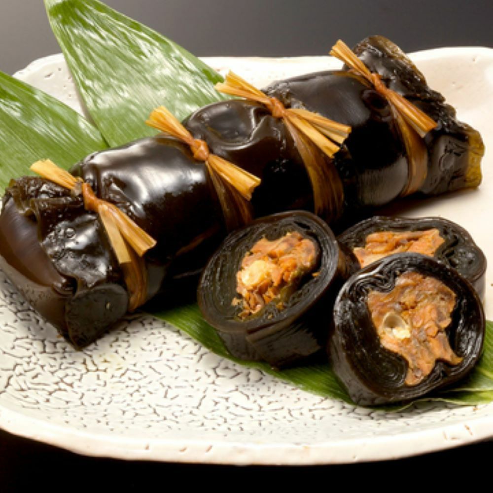 ますの身と骨が昆布で包まれ、柔らかく煮込んだジャンボます昆布巻がお皿に盛りつけされた画像です。