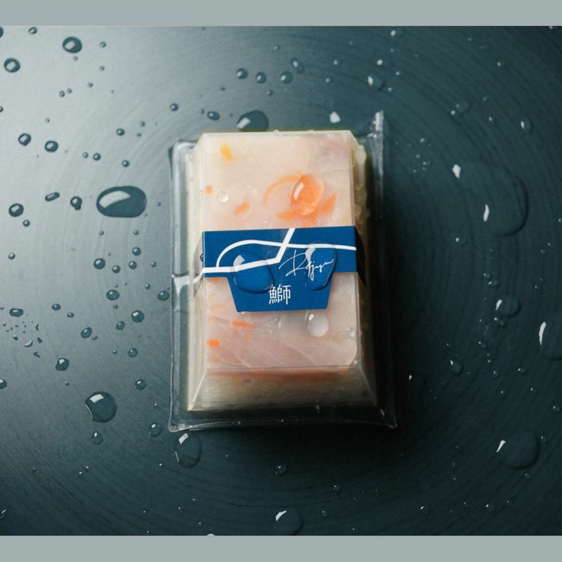 透明容器に帯が巻いてあるRejyu（レジュウ）の鰤の水感のある画像です。