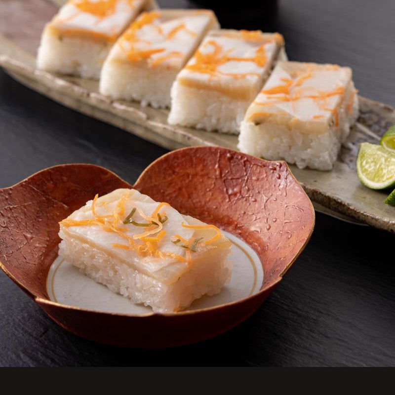 Rejyu（レジュウ）のぶりがお皿に盛りつけられているイメージ写真です。かぶらずしから着想を得た見た目にも楽しい押し寿司のイメージ画像です。