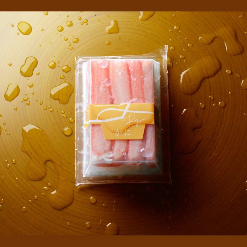 透明容器に帯が巻いてあるRejyu（レジュウ）の蟹の水感のある画像です。